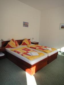 ein Schlafzimmer mit einem Bett mit einem Holzrahmen in der Unterkunft Pension San Francisco in Wien