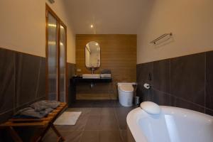a bathroom with a tub and a sink and a mirror at BaanTataChiangmai in Ban Pong Khai Tai +40 photos