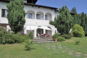 une maison blanche avec des arbres devant elle dans l'établissement Villa Morissolina, à Trarego