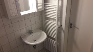 un bagno bianco con lavandino e specchio di Haus Steeg a Braunlage Altre 60 foto