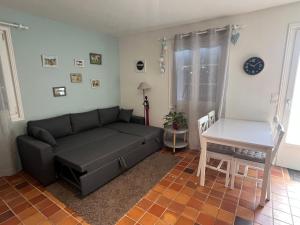 a living room with a couch and a table at Le Poule House in Guérard