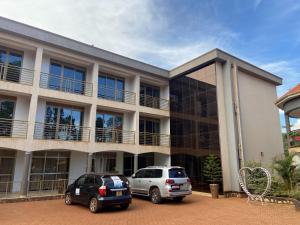 two cars parked in front of a building at Spark Africa Hotel in Jinja