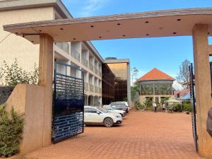 a parking lot with cars parked in front of a building at Spark Africa Hotel in Jinja