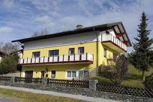 Una casa amarilla con balcón en la parte superior. en Haus Sonnenschein Mariapfarr, en Mariapfarr