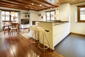 a kitchen with white cabinets and a dining room with a table at Val de Ruda Luxe 6 by FeelFree Rentals in Baqueira-Beret