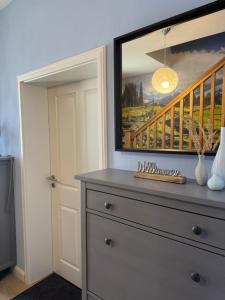a dresser in a room with a painting on the wall at Pension "Zum Romröder Steingarten" in Romrod +13 photos