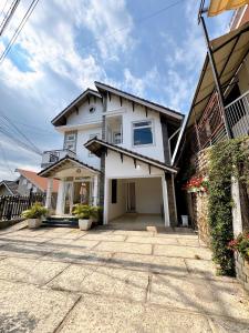 a white house with a driveway in front of it at Tuong Vy Private Villa in Da Lat