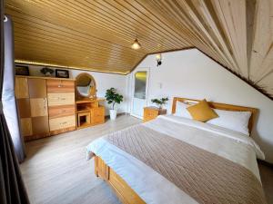 a bedroom with a large bed and a wooden ceiling at Tuong Vy Private Villa in Da Lat