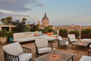 a patio with couches and tables and a view of a city at Bvlgari Hotel Roma in Rome +34 photos