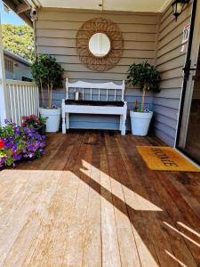 a white bench sitting on a porch with flowers at North Hamptons Retreat in Bundaberg
