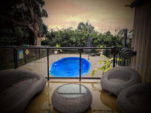 a small blue pool with two chairs and a fence at North Hamptons Retreat in Bundaberg