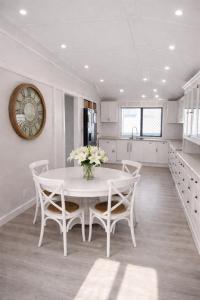 a kitchen with a table and chairs and a clock at North Hamptons Retreat in Bundaberg