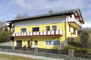 a yellow house with a balcony at Haus Sonnenschein Mariapfarr in Mariapfarr