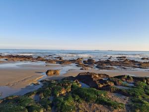 a beach with rocks and the ocean in the background at Sandhills Holiday Park Astounding Sea Views in Bembridge