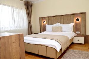 a bedroom with a large bed with a wooden headboard at Pensiunea Maria in Agapia