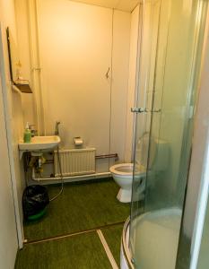 La salle de bains est pourvue de toilettes, d'un lavabo et d'une douche. dans l'établissement Minimotel, à Tohmajärvi