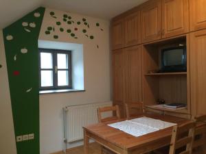 Un comedor con una mesa y una ventana. en Apartments Kozjanski park, en Podsreda