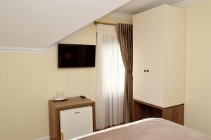 a bedroom with a bed and a dresser and a window at Pensiunea Maria in Agapia