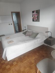 a large white bed in a room with a wooden floor at Apartma za 2 Marko Rogaška Slatina in Rogaška Slatina
