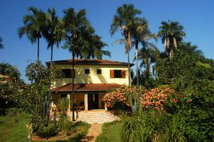 ein Haus mit Palmen davor in der Unterkunft Pousada Rosa dos Ventos in Delfinópolis