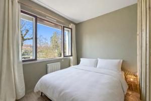 a bedroom with a white bed and a window at Chez La Mamie in Saint-Jean-de Niost