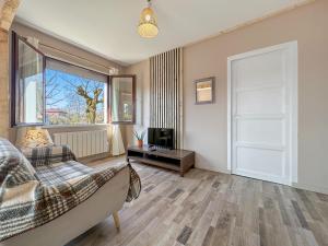 a living room with a couch and a television at Chez La Mamie in Saint-Jean-de Niost