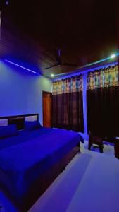 a bedroom with a bed with blue lights on it at Hotel Preet La Casa in Thānesar