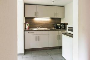 a kitchen with white cabinets and a sink at Ferienhaus Eldeblick direkt am Eldeufer in Parchim in Parchim +35 photos