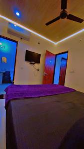 a bedroom with a purple bed with a ceiling fan at Hotel Preet La Casa in Thānesar +26 photos