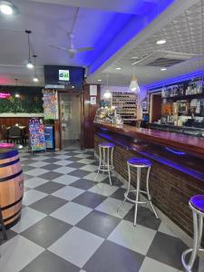 a bar with purple lighting and stools in a restaurant at Hostal Restaurante Piedra in Limpias