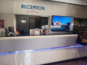 una zona reception di un ristorante con un televisore di Appart'hotel le Pèlerin a Lourdes
