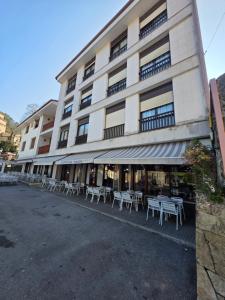 a building with tables and chairs in front of it at Hostal Restaurante Piedra in Limpias