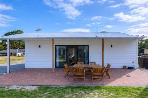 a house with a table and chairs on a brick patio at The French River Chalets in Kalgan