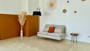 a living room with a chair with an orange pillow at Samma Villas - Onyx Villa - 1 BDR & Private Pool in Ko Phangan