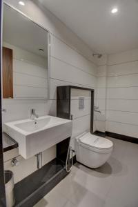 a bathroom with a sink and a toilet and a mirror at Hotel Dreamland in Pune +15 photos