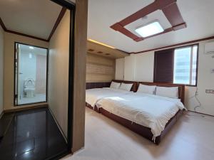 a bedroom with a bed and a large window at Romance Hotel in Seoul
