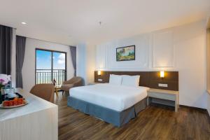 a hotel room with a large bed and a kitchen at Hon Chong Retreat Hotel Nha Trang in Nha Trang