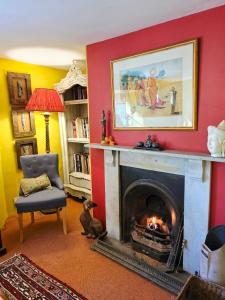 a living room with a fireplace with a painting above it at The Annexe Lurley Manor in Tiverton