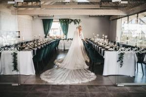 a bride in a wedding dress in a room with tables at Penzión Grobský Dvor in Slovenský Grob