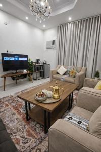 a living room with a coffee table and a tv at Smo Hail سمو حائل in Hail