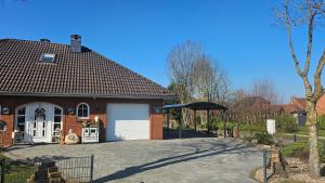 a brick house with a garage and an umbrella at Ferienhaus Gerda in Osteel