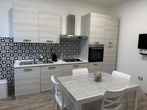 a kitchen with a table with chairs and a kitchen with a stove at EDEL Vacation Home in Terni