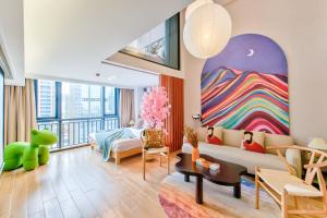 a living room with a couch and a painting on the wall at Yangji Yeju in Zhuhai