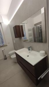 a bathroom with a sink and a toilet and a mirror at Casa Nulfa in Sommacampagna