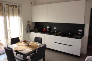 a kitchen with white cabinets and a table with chairs at Casa Nulfa in Sommacampagna