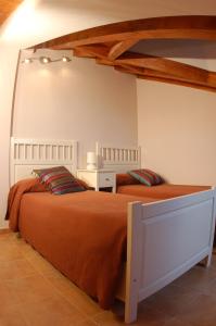 1 dormitorio con 2 camas y edredón de naranja en Casa Rural El Esquilador, en Terminón