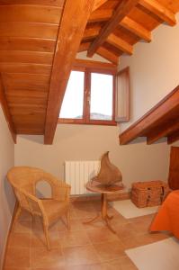Habitación con techo de madera, mesa y silla. en Casa Rural El Esquilador en Terminón