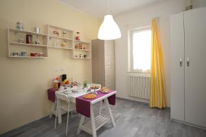 a kitchen with a purple table and chairs and a window at B&B Gli Alberetti in Loreto