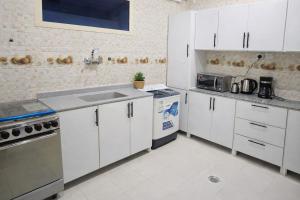 a kitchen with white cabinets and a sink at Smo Hail سمو حائل in Hail