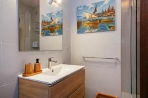 a bathroom with a sink and two paintings of boats at Villa Maravilla in Lloret de Mar +42 photos